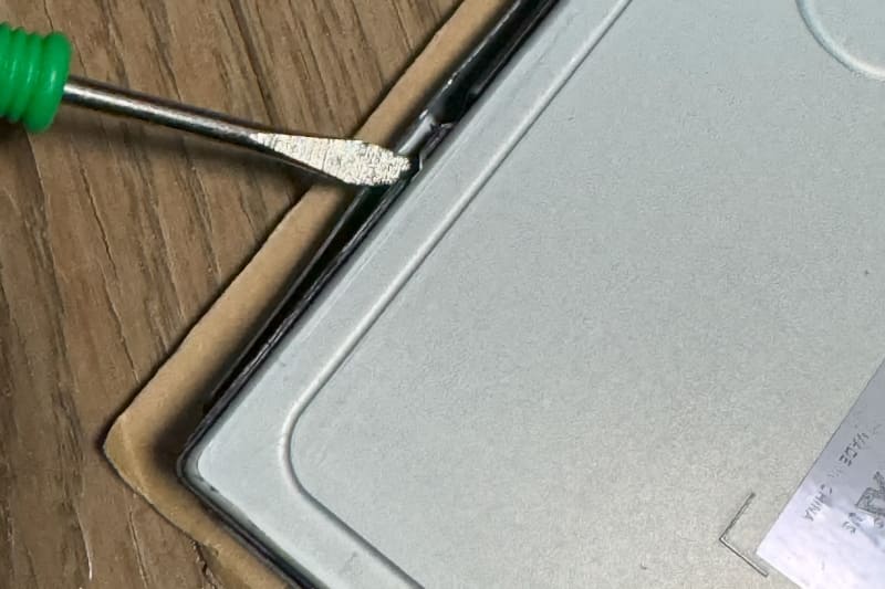 液晶パネルにもツメがあるため、こちらもマイナスドライバでこじ開けていく