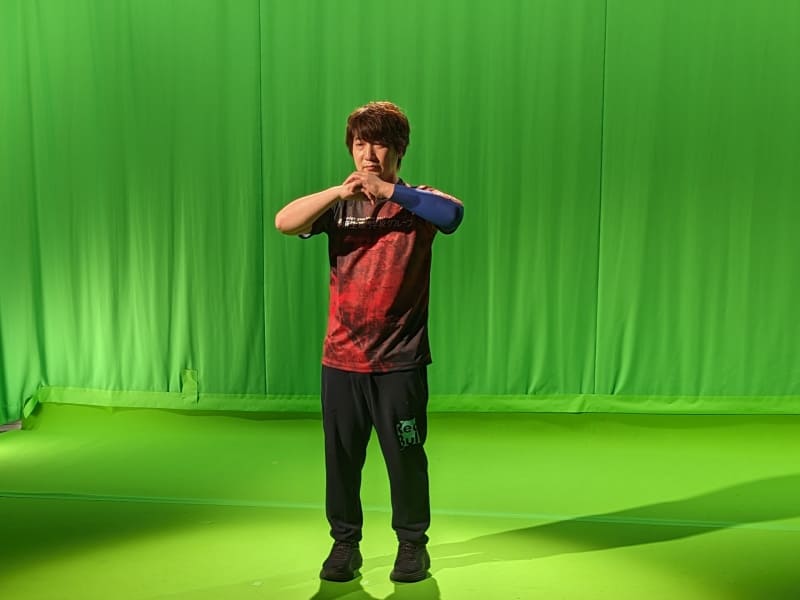 動画撮影中のポーズを決めるウメハラのワンカット。2023年にリーグを休んだウメハラに、1年ぶりのSFLについて聞くと、リーグの大変さは知っているので楽しみ半分、憂鬱半分みたいなところはあるが、レベルも上がっているし、メンバーもストリートファイターVの頃と比べて結構変わっているので、この新しいメンバーとの新しいゲームでも勝ちたいと思っているとした