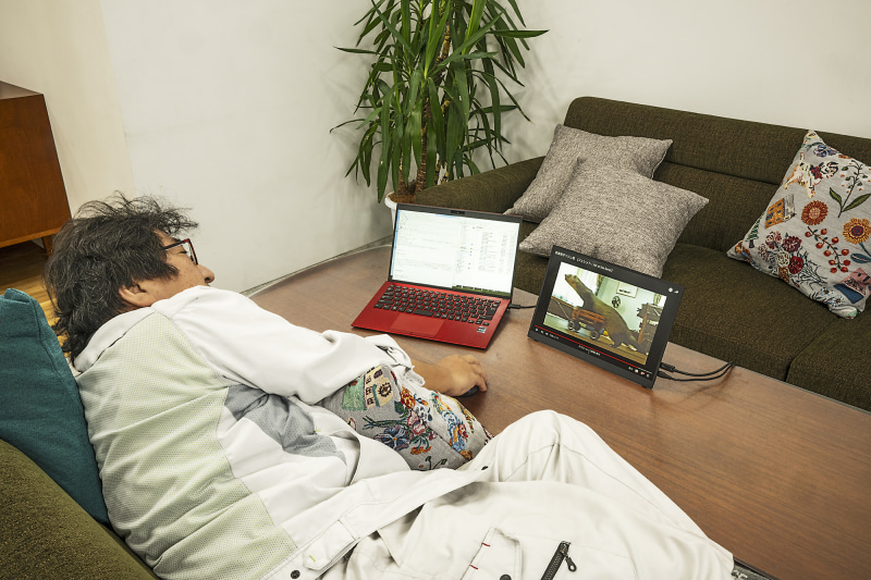 家でYouTubeを見ながらだるく仕事している様子