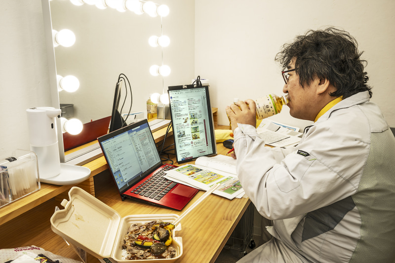 楽屋で弁当をつまみながら縦置きで使用するの図