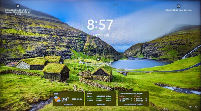 Windows 11のロック画面。ロック直後は日時しか表示されていないが、暫く放っておくと、おすすめ情報などが表示されるようになる。なお、下部の天気や株式情報はウィジェットの情報のため、広告やおすすめ情報とは若干扱いが異なる
