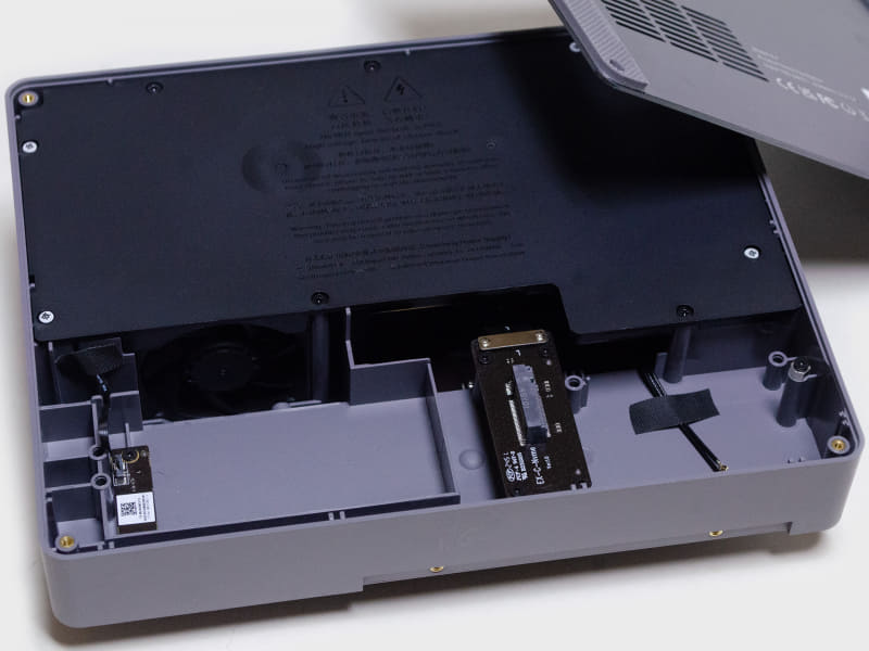 裏を開けたところ。右側にM.2 2280 1つ搭載可能(ただしPCle 4.0 x1)。黒いカバーの下に600W電源ユニット