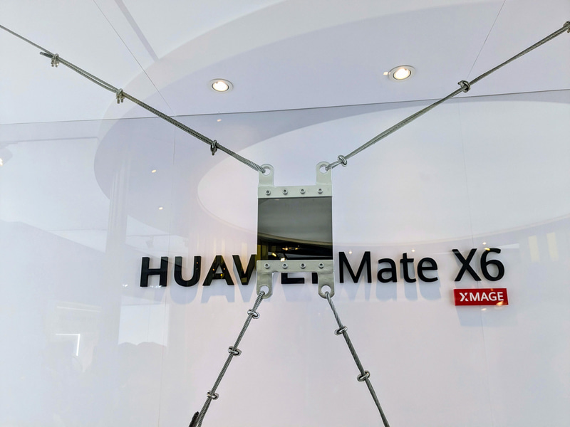 HUAWEI Mate X6の本体内部にあるカーボンファイバーの耐久性を示すデモ。バイクを吊るしても大丈夫