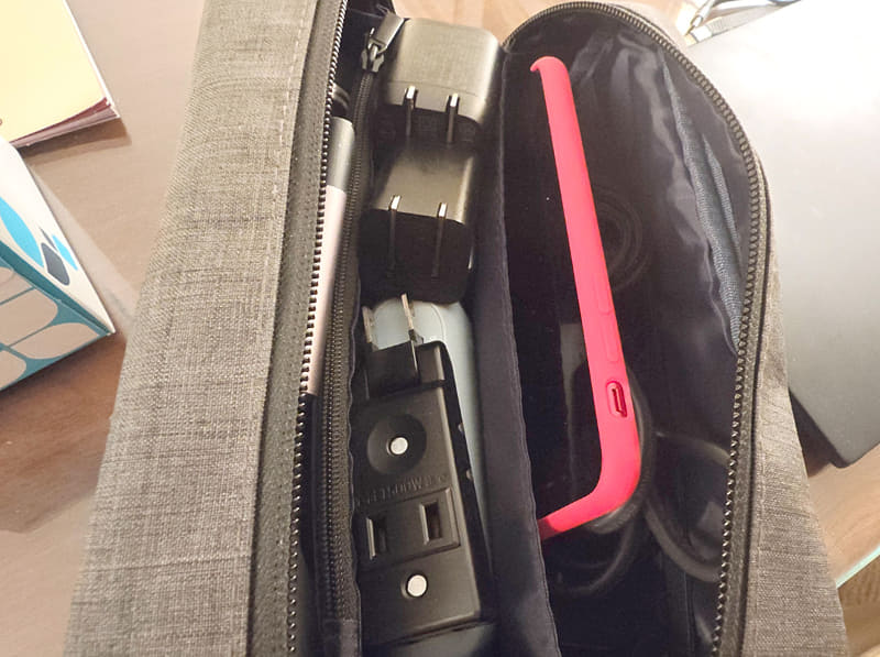 スーツケースのケーブルいれにいつもいれてある赤いiPhone SE(第3世代)