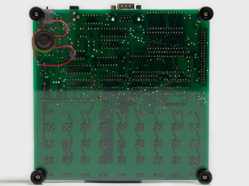 製品写真(裏)。アクリルパネル上に基板を配置。左側にスピーカー