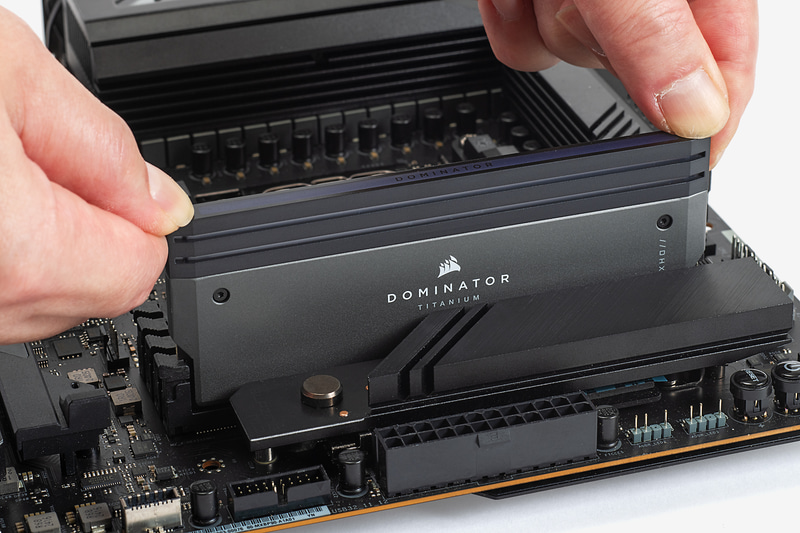 メモリを垂直に挿し込む。両側のフックが自動的に戻ってメモリが固定されるまでしっかりと押し込もう