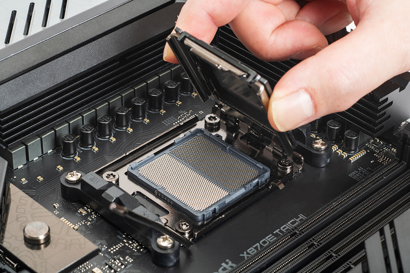 ソケットカバーの両脇をつまみ持ち上げる。これでCPUソケットの接点が見える