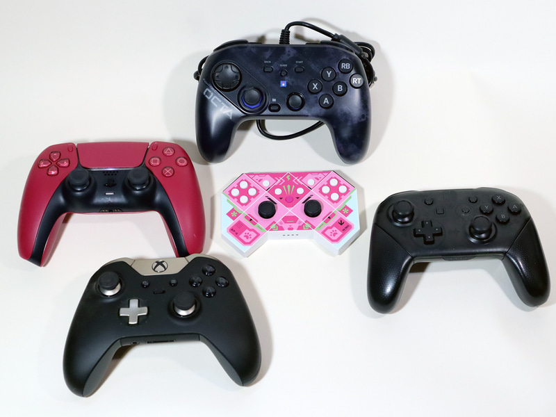 筆者所有のゲームコントローラの一部。かなりさまざまなレイアウトのものが発売されているのが分かる。