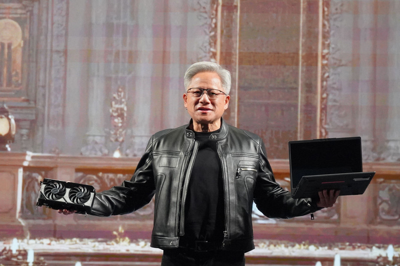 右手(向かって左)にGeForce RTX 5060を、左手(向かって右)にdGPU入ノートPCを持つフアン氏