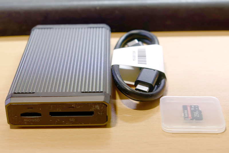 【写真11】PRO-READERは金属製でグレーを基調とした、これも同社の他の製品と同じデザイン。寸法は115mm×60mm×17mm、重量は179.9g(いずれも実測値)と、ちょっと重い。USB Type-Cケーブルが付属する