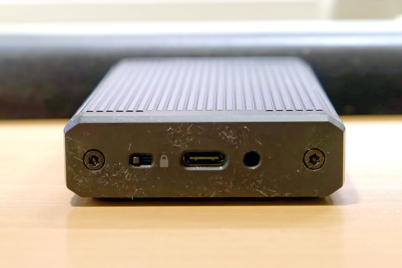 【写真12】背面にUSB Type-Cコネクタと、その左脇には書込み防止用のロックスイッチがある。謎なのがコネクタ右脇の丸穴で、説明書にも言及がないし、特に奥にスイッチが隠されているわけでもなかった