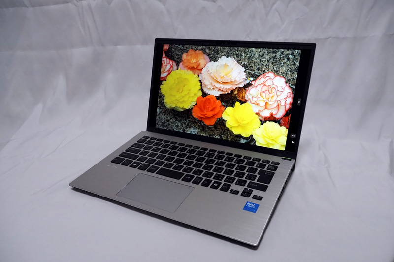 14型ながら狭額縁を採用することでサイズを抑えている。専用の壁紙は本体カラーに合わせた色のものが付属する。10万円台のスタンダードノートのディスプレイとしては色の再現性もよい