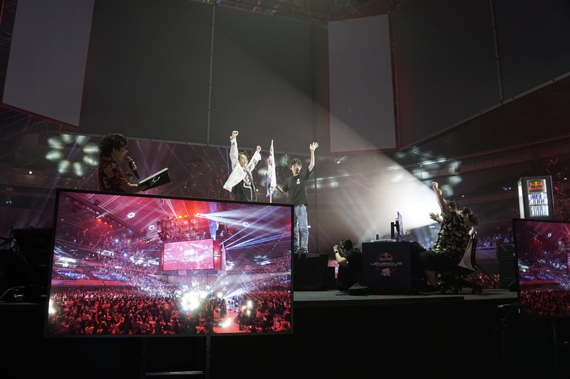 ステージに用意された頂にマノンの旗を立てる両氏