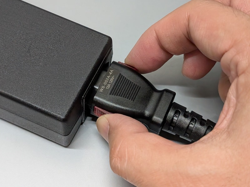 抜く時はそのまま引っ張ってもびくともしない。側面の赤いつまみをスライドさせながら引っ張ることで初めて抜ける仕組みだ