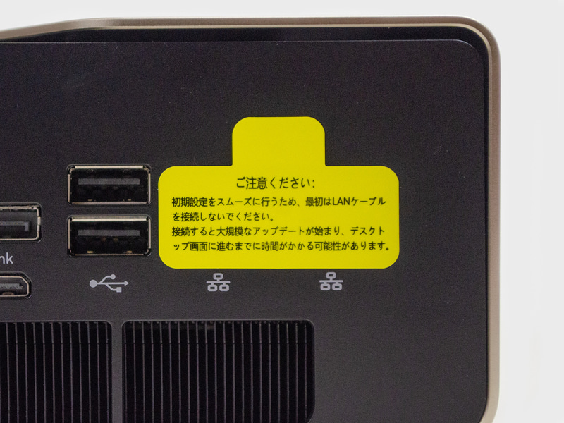 背面の拡大。2.5GbE 2基の上に貼られているシールを拡大。「最初はLANケーブルを接続しないでください。～大規模なアップデートが始まり、デスクトップ画面に進むまでに時間がかかる…」とある