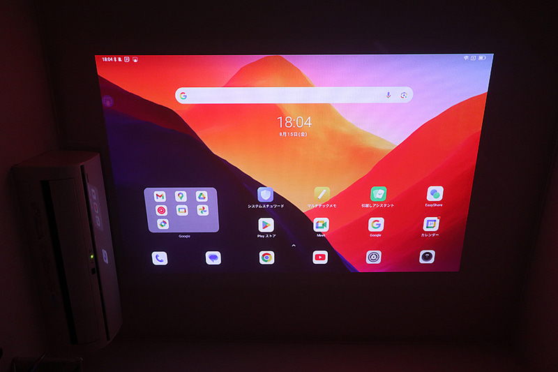 床置きで天井に投影したところ。天井に近いベッドだとここまで大画面にはならないが迫力は満点だ