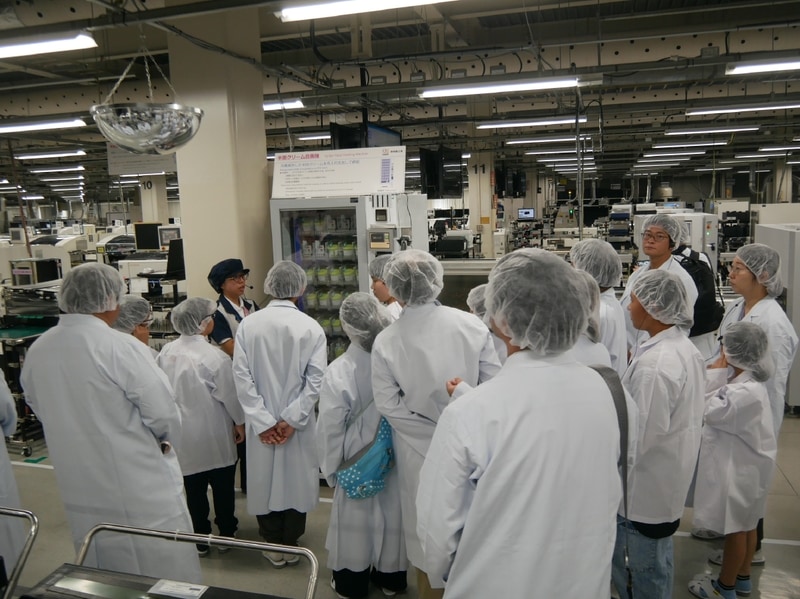 ブリント基板製造ラインを見学する参加者たち