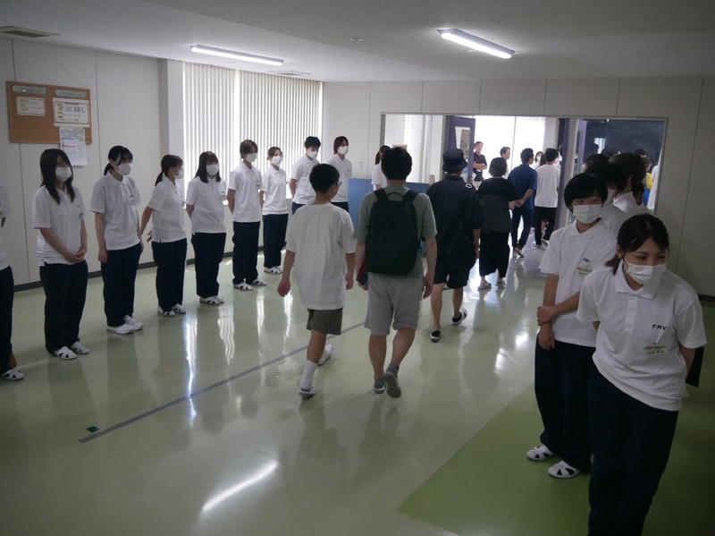 組み立て会場に入る参加者たち。社員が迎えた