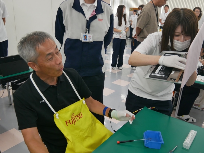 作業をサポートする島根富士通の錦織舞さんが接続をチェック。「OKです！」の言葉に安堵する高嶋執行役員常務