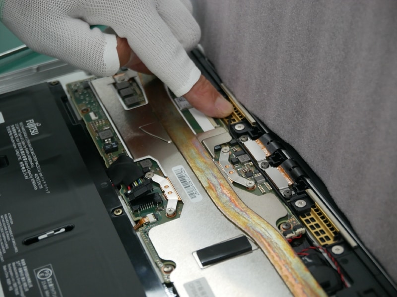 続いてケーブルの配線作業を行なう。メインボードと金具の間に押し込むように作業する