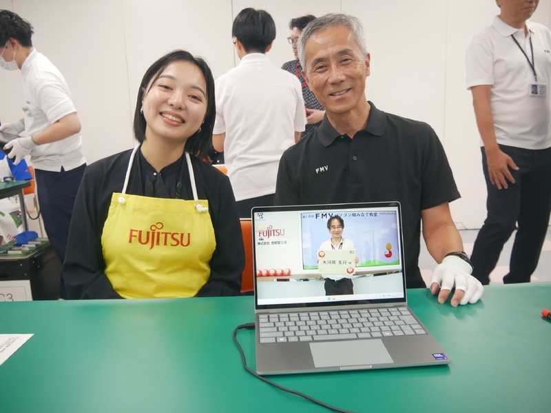 完成したFMV Note Cを前に記念撮影。高嶋執行役員常務は、「生産ラインは何度も見ているが、実際に組み立て作業をしてみて、これらの作業を短時間に行なう島根富士通の社員のすごさを感じた。匠の技によって作られていることを実感した」と語っていた