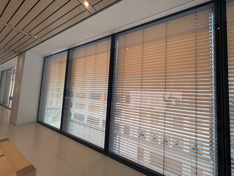 可動ルーバーを備えたダブルスキンガラスファサードが、一日を通じて明るさと室温を調整する