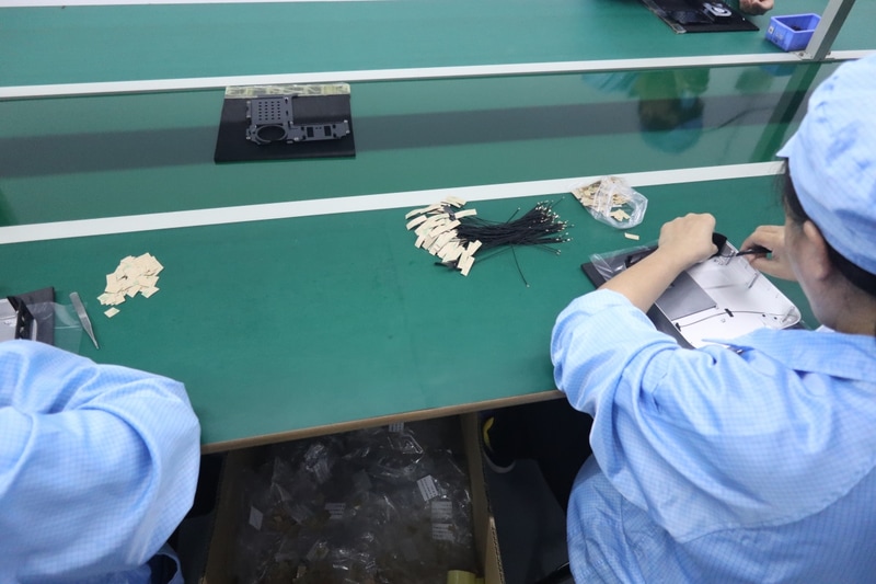 メインの製造ラインとは別室で、外装にWi-Fiアンテナを貼り付けるといった事前の作業が行なわれている
