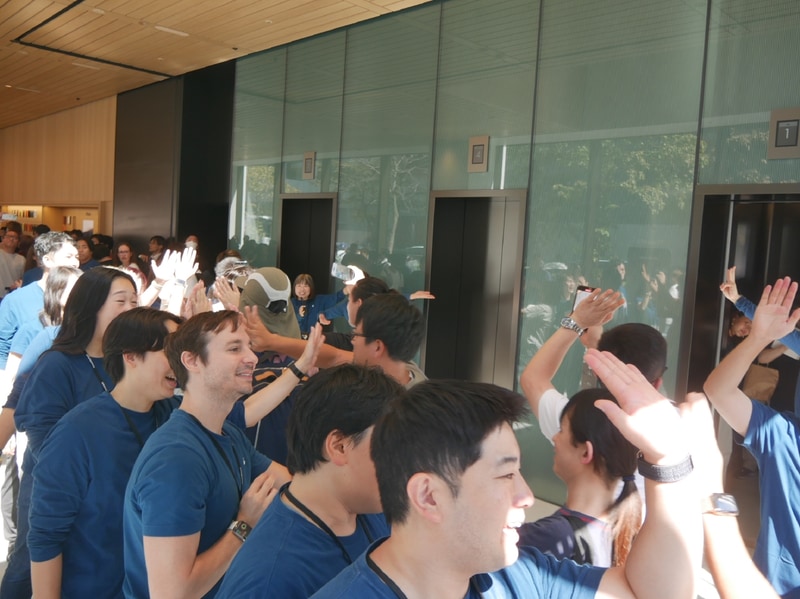 スタッフとハイタッチしながら店内に入る来店客