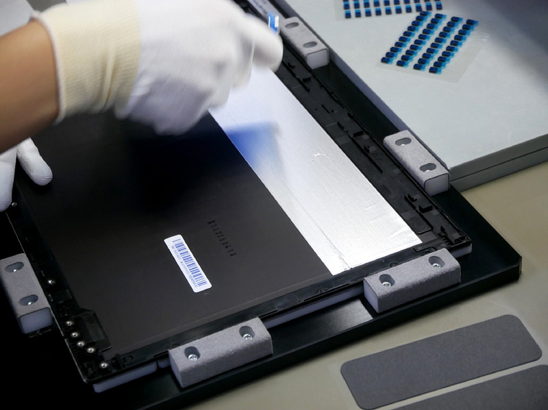 新品の生産工程と同じ手順で天板部分に部品を取り付ける