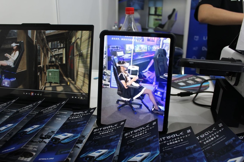 使用イメージ。本体がゲーミングチェアとアームでつながっている