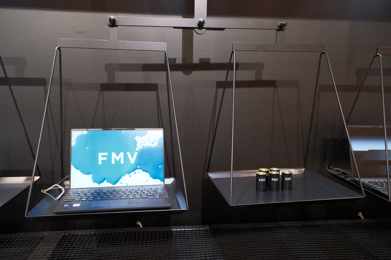 FMV Note Uの重量が身近なもので再現されている(左は単1形乾電池5本、右はペットボトル)