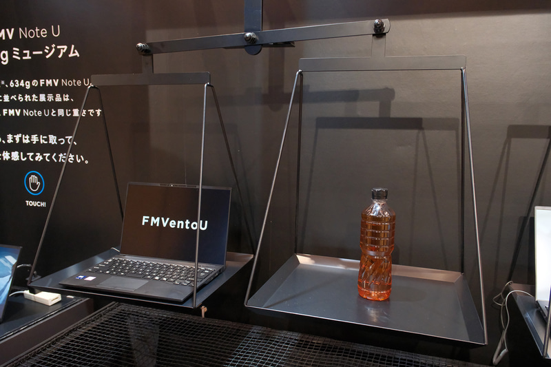 FMV Note Uの重量が身近なもので再現されている(左は単1形乾電池5本、右はペットボトル)