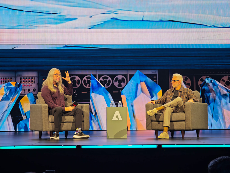Adobe MAX 2025の2日目の基調講演に登壇したジェームズ・ガン氏(右)、左はAdobe フェロー ジェーソン・ラビーン氏
