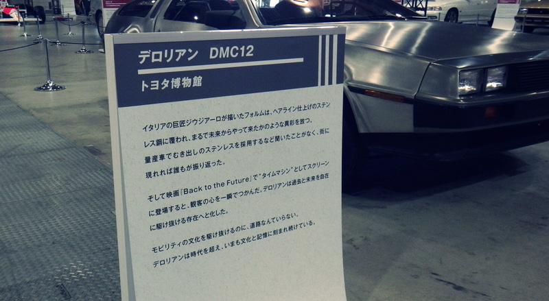 「デロリアン(DMC-12)」の展示説明板。個人的な感想だが合同企画展示「タイムスリップガレージ」の中で、この説明書きだけは筆者の理解力を超えていた。2025年10月30日に筆者が撮影