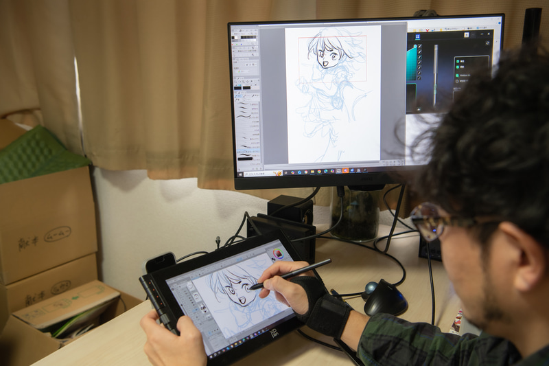 左手のボタン類を使いながらに作画する宮下先生