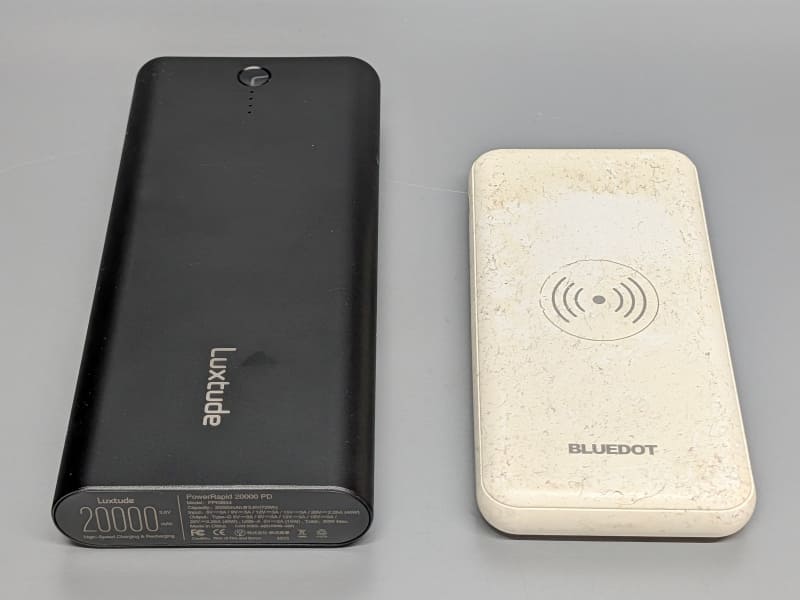 回収対象のモバイルバッテリ。申込時は3個だったが、2カ月半待たされている間に1つ処分され2個になった。右は加水分解のベタつきで埃が付着している