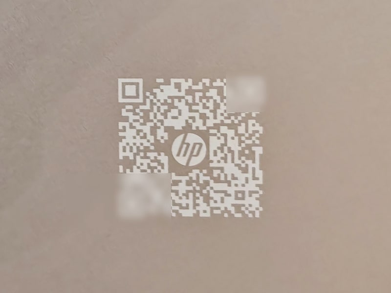 HPのノートPCの底面に用意されているQRコード、これをスマートフォンなどで読み取るとそのシリアルナンバー固有のサポートサイトに飛べる(写真撮影筆者、コードは撮影後に一部マスク)