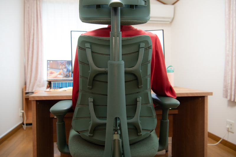 背筋に沿った縦の支持は背骨構造で支える。リブは自由に動かせるので、ゲーミングチェアのようなフルバケットに比べ圧迫感がない