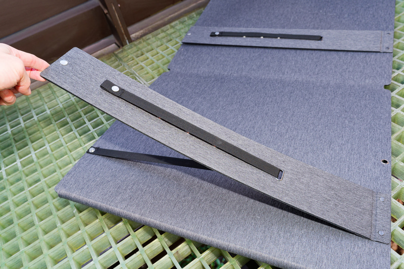 背面にある脚を開いて地面に設置して使えるほか、吊り下げにも対応する