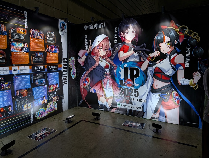ぶいすぽっ！ブースには3人のVTuberたちのイラストをバックに写真が撮れるフォトスポットを用意。SFL2025リーグ本節のダイジェスト年表も壁に貼られており、気合いの入った展示となっていた