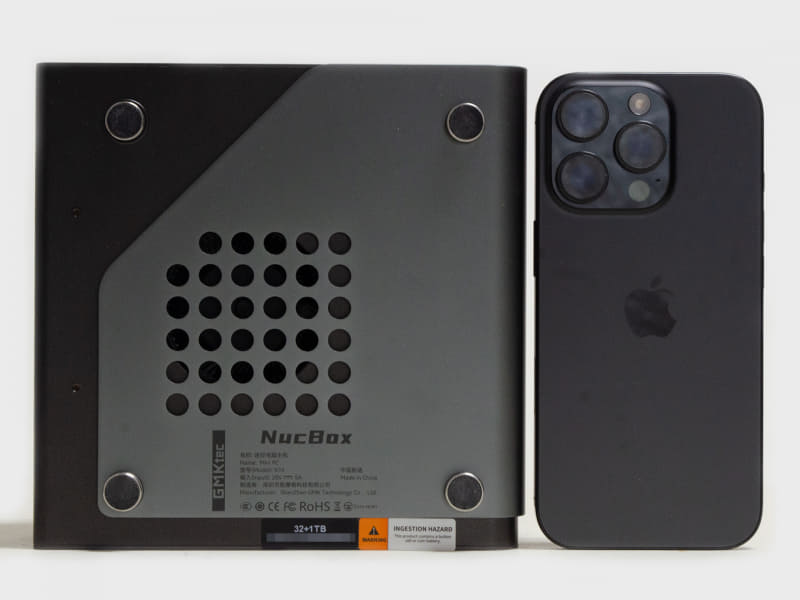 裏面とiPhone 16 Pro。4隅にゴム足。iPhone 16 Proの比較からも分かるようにミニPCとしては大きめ