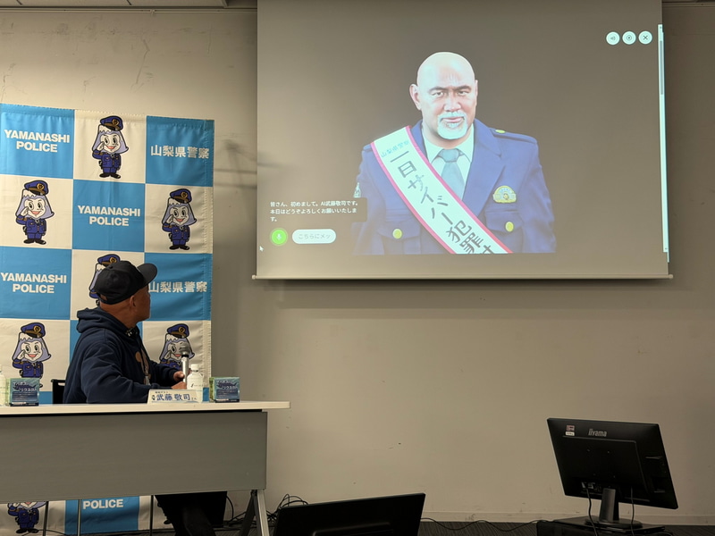 デジタルヒューマンである「AI武藤敬司サイバー犯罪対策課長」と対話する武藤氏。「神奈月と対話させてみたい」とのコメントも