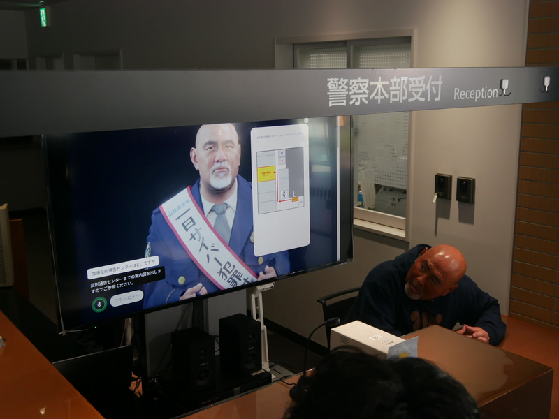 デジタルヒューマンの横に座って、ちゃんと回答ができているのかどうかを確認する武藤氏