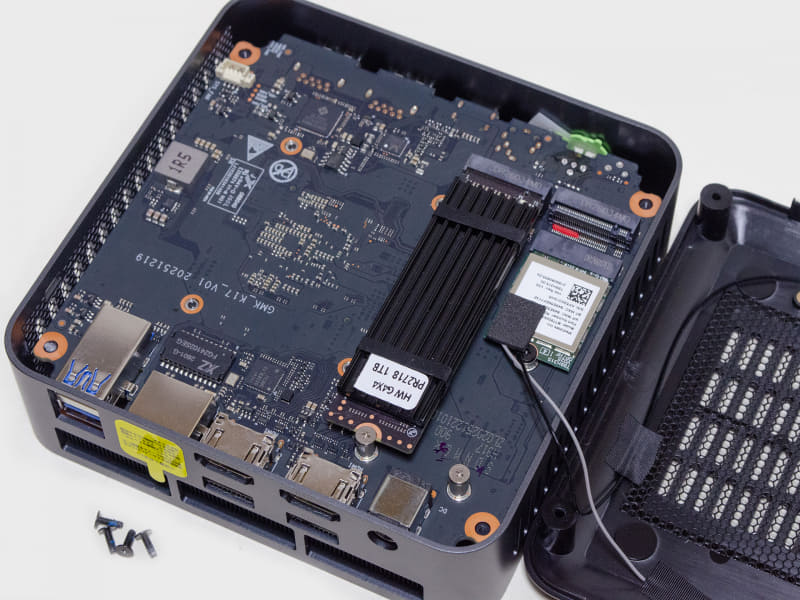 四隅のネジを外すだけと難易度は低い。裏蓋にWi-Fiのアンテナが接続されているので外す時は要注意！2つのM.2スロットが見える(1つ装着済み)