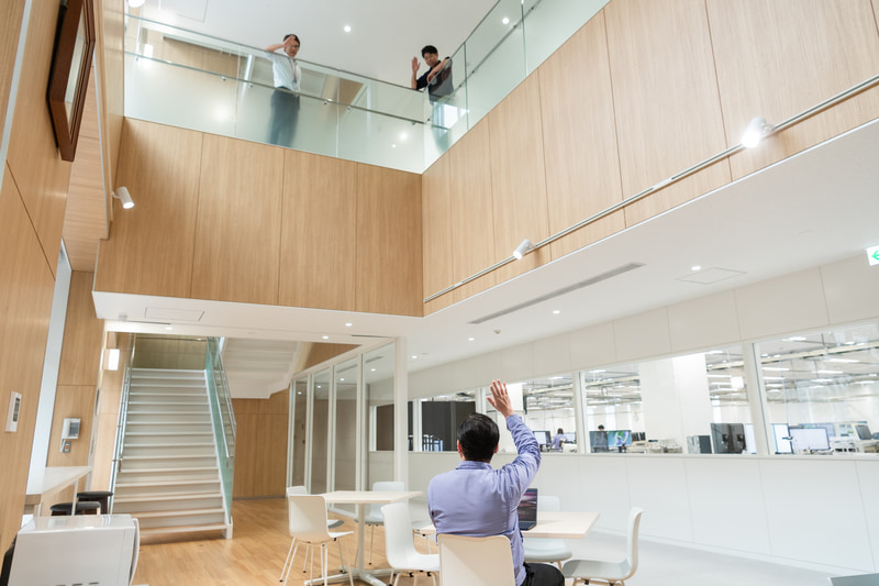 社内建屋は、吹き抜け・風通しの良いレイアウトなど、フロア・部門の垣根を取り払うオープンな雰囲気がある