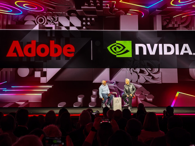 Adobe Summit 2026の基調講演にゲスト登壇したNVIDIA CEOのジェンスン・フアン氏(右)、左はAdobe CEOのシャンタヌ・ナラヤン氏