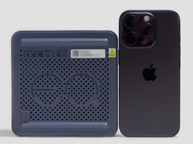 裏面とiPhone 16 Pro。ミニPCとしては標準的。四隅の丸い目隠しの下にネジがある