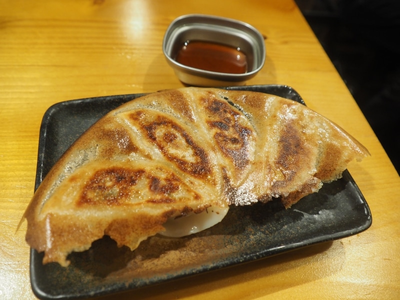 最初の串焼きが出てきてから約10分後に、博多鉄板餃子が出てきた。しっかり味のついた餡がたっぷりはいっており、羽根もパリパリしていて美味しい。数は1人あたり2個ずつだ