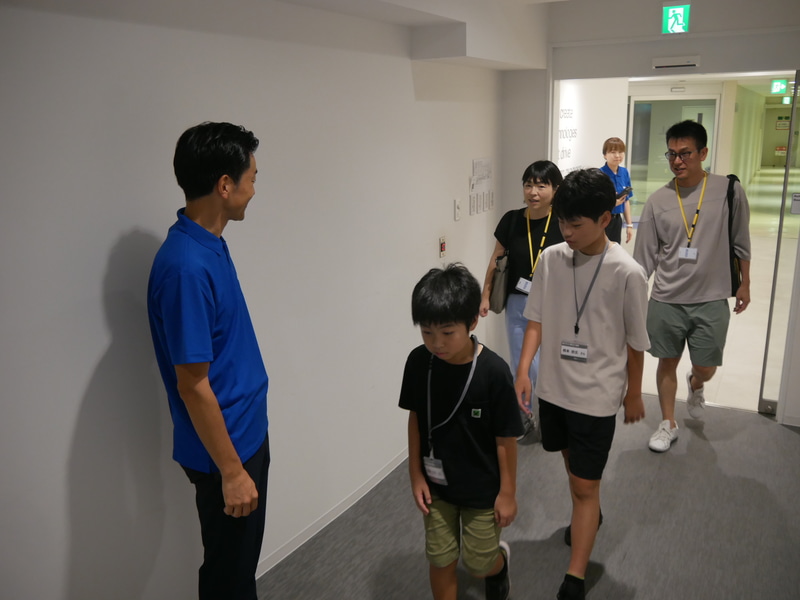 会場の入口で参加者を迎え入れる林田センター長