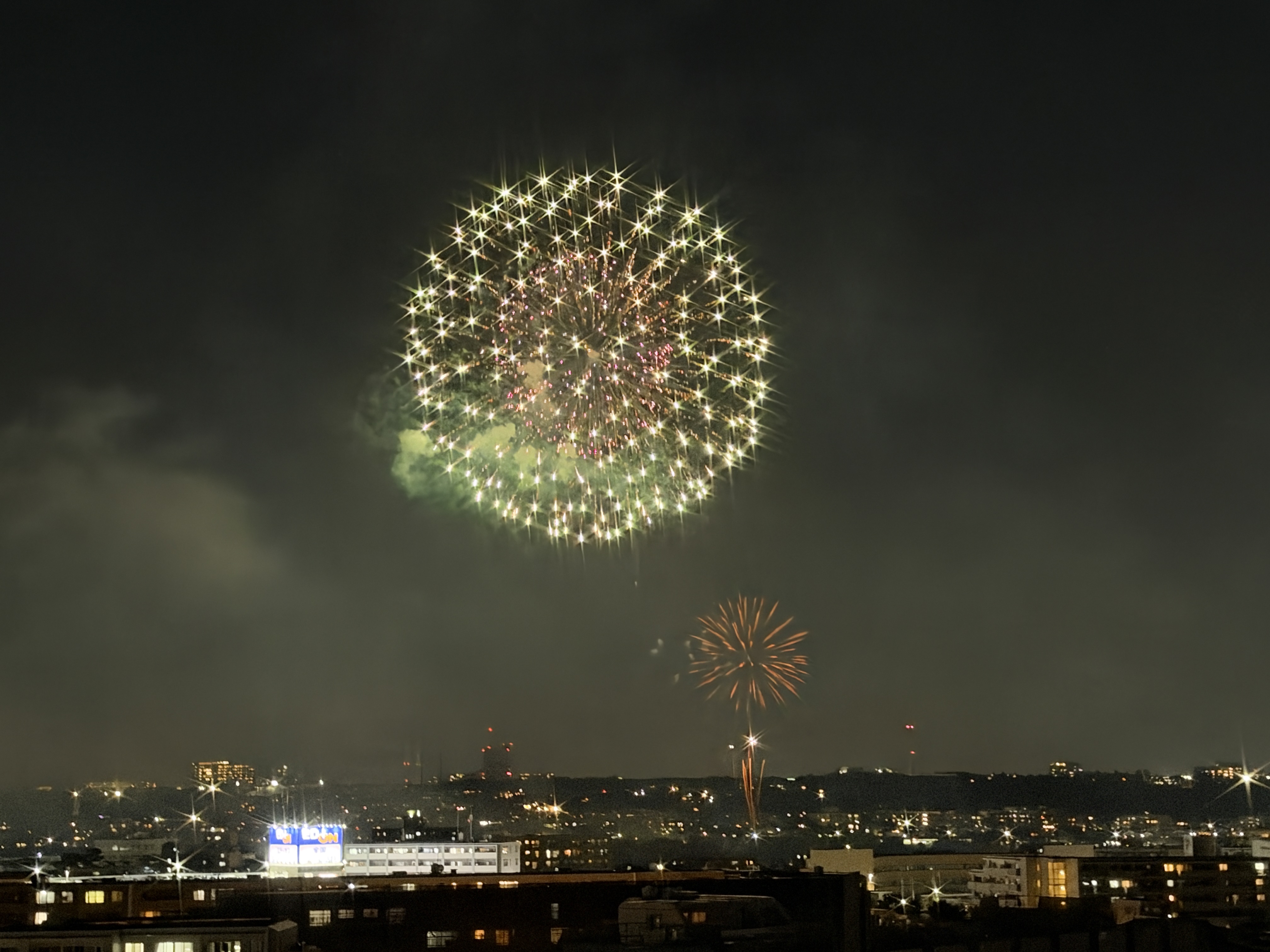 F4.0、1/15秒、ISO5000、35mm判換算64mm、4,032×3,024ドット、F4.0で撮影すると、花火の明るい点に星形の光条が発生。大玉の外周に光条が並んでおり、F1.48で撮影した写真とは印象が大きく変わる